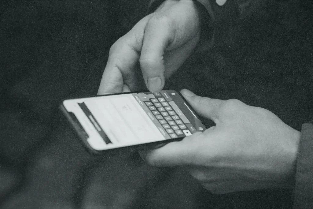 An image of a person using a phone. Only the hands and phone are visible.